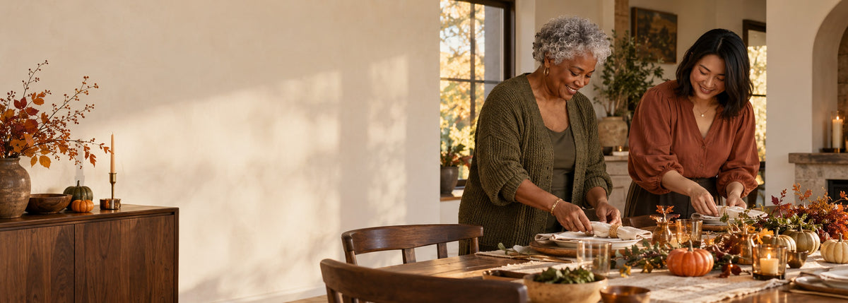 Two adults preparing a Thanksgiving table in a warm autumn home